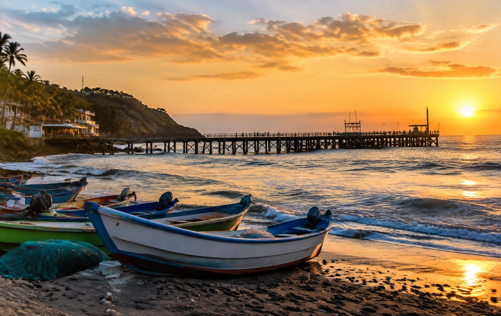 Fishing boats and the pier at the port of La Libertad at sunset